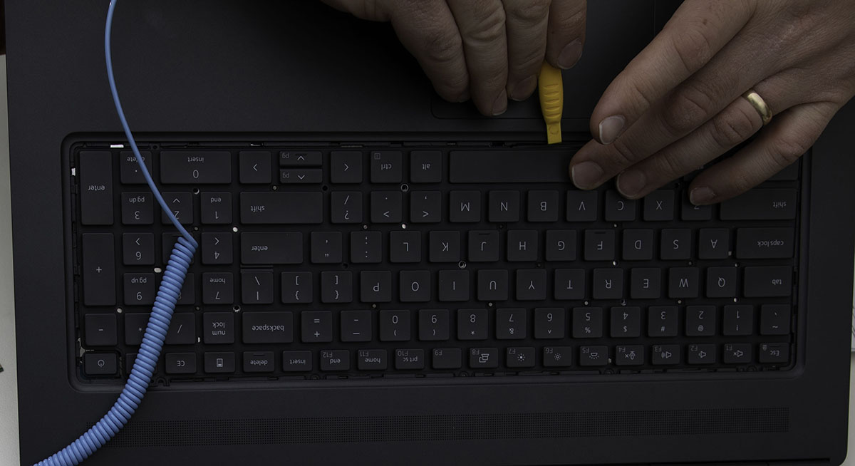 Picture showing how to reseat the ribbon cable when reinstalling the keyboard.
